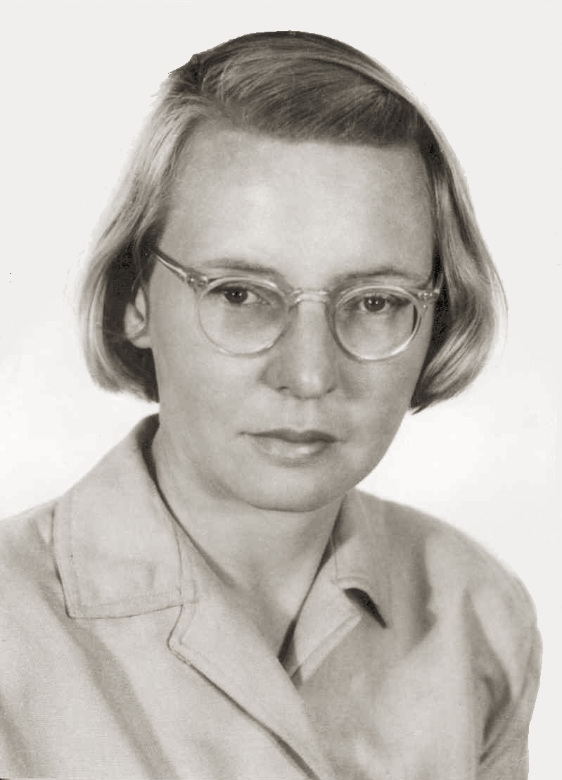 Fotografía de Emmy Noether de pie junto a una silla.